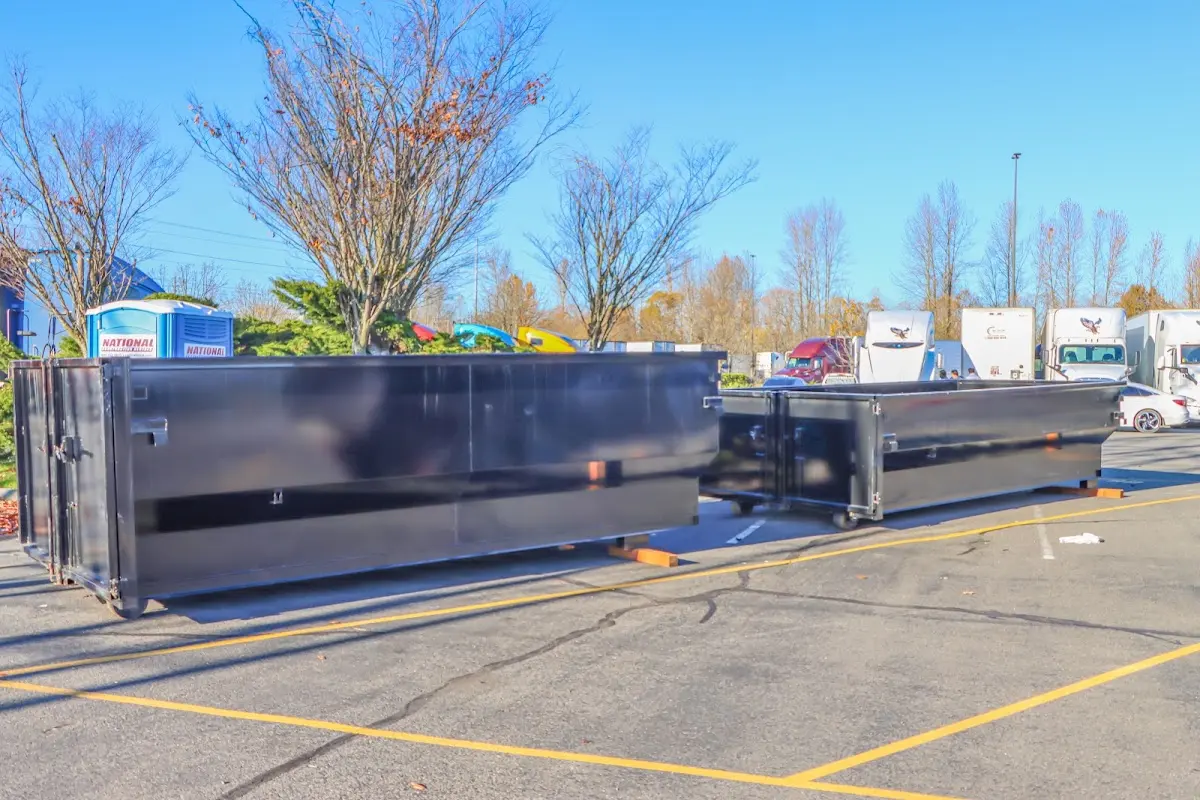 Professional dumpster rental service with roll-off container on residential driveway in Bedminster